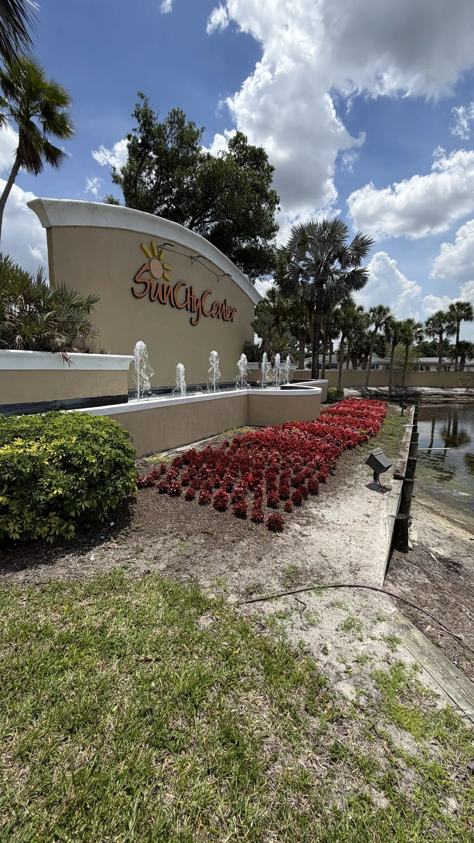 Sun City Center main entrance sign with red flowers